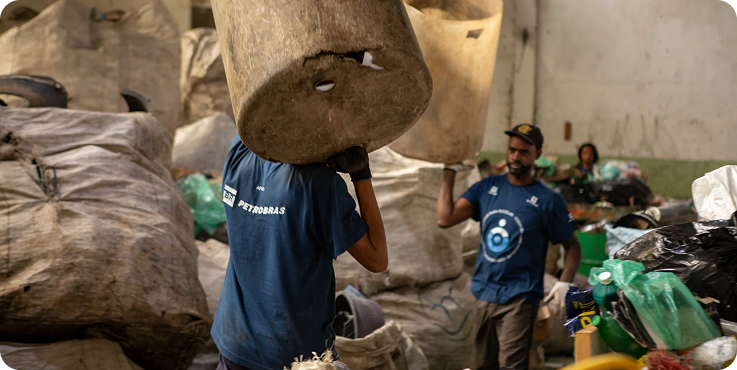 Trabalhadores da cooperativa Coopama movimentando materiais recicláveis em galpão no Jacarezinho