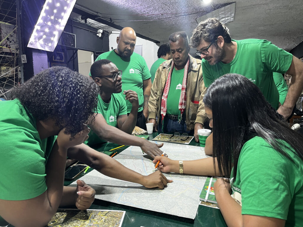 Imagem de agentes comunitários e membros da equipe de mapeamento trabalhando em um mapa