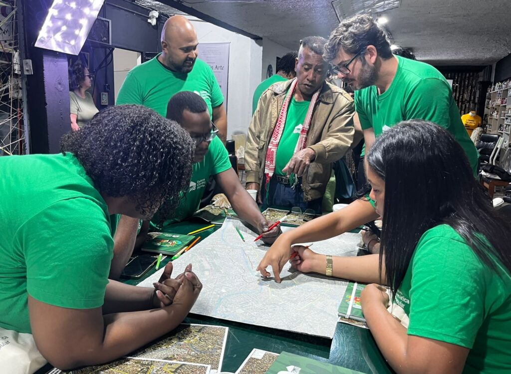 Imagem de agentes comunitários e membros da equipe de mapeamento trabalhando em um mapa